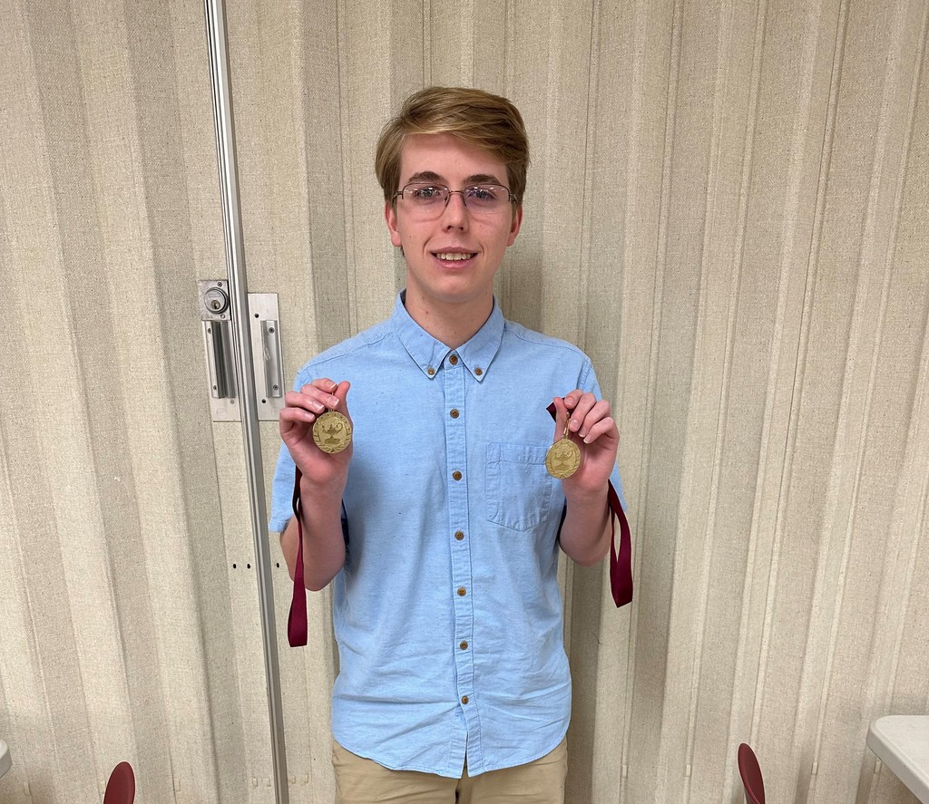 Student holding medals from UIL Competition